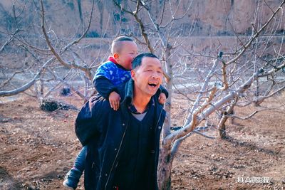 Boy and son on tree during winter