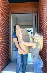 Rear view of couple holding hands while standing in house