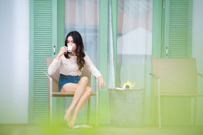 Full length of woman sitting on seat