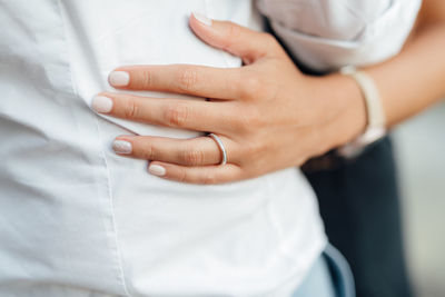 Midsection of couple embracing at home