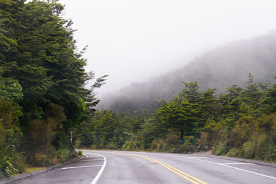 Road amidst trees against sky