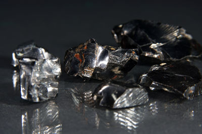 Close-up of ice crystals on rock against black background