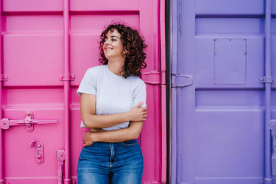 Young woman standing against door of building