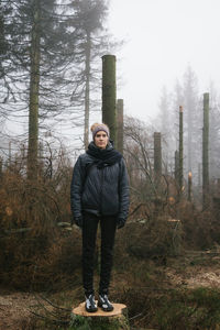 Full length portrait of young woman standing in forest