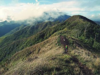 Rear view of man on mountain against sky