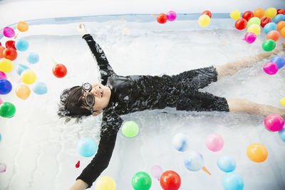 High angle view of boy floating on water in wading pool