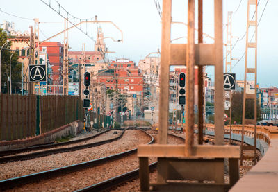 Railroad tracks in city against sky