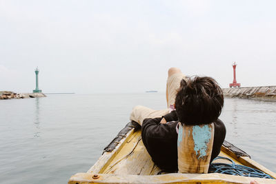 Rear view of woman looking at sea against sky