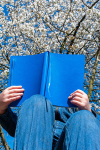 Midsection of person holding book