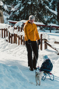 Rear view of man skiing on snow covered field