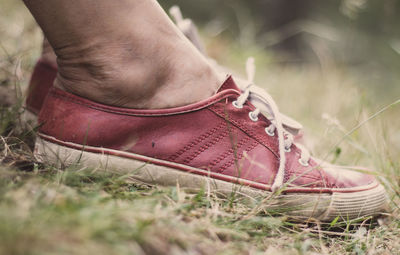 Low section of person wearing shoes on field