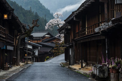 Street amidst houses and buildings against sky