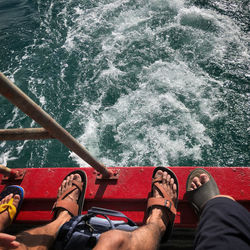 Low section of men on boat in sea / together