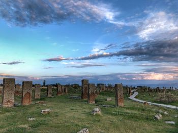 View of cemetery on field against cloudy sky
