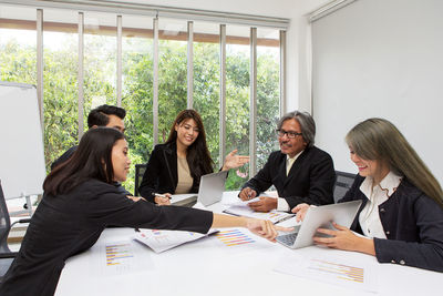 People discussing over laptop on table