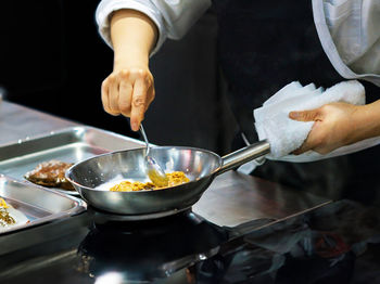 Midsection of chef preparing food in kitchen