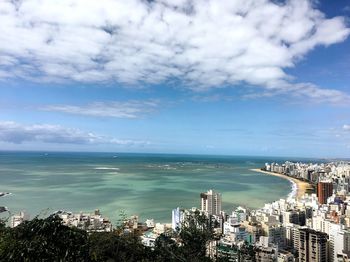 High angle view of city by sea against sky