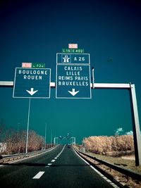 Road sign on highway against clear sky