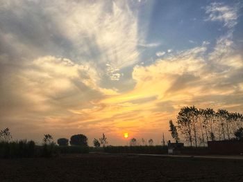 Scenic view of silhouette field against sky during sunset