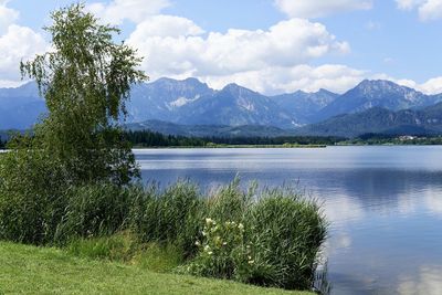 Scenic view of lake by mountains against sky