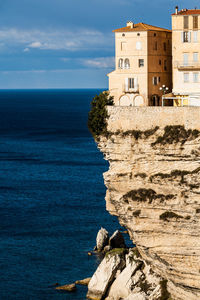 Rock formations by sea against sky