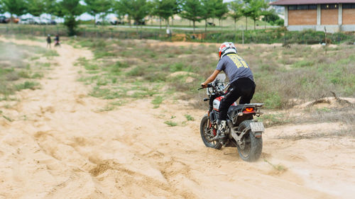 Man riding motorcycle on dirt road