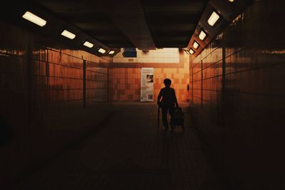 Full length of man walking in illuminated tunnel
