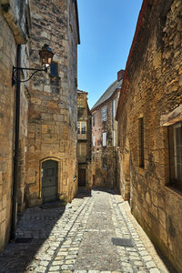 Narrow alley amidst old buildings against sky