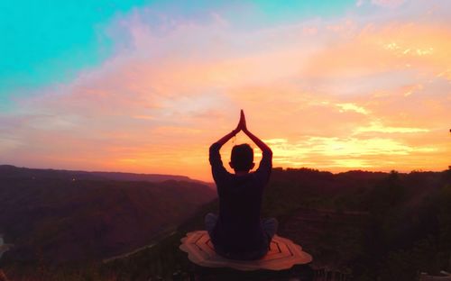 Midsection of man against orange sky during sunset