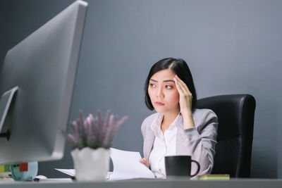 Low angle view of businesswoman with head in hands working at desk