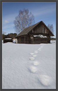 House on field against sky during winter