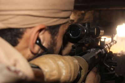 Close-up of soldier aiming with gun