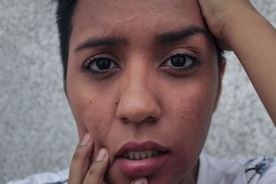 Portrait of young woman touching cheek