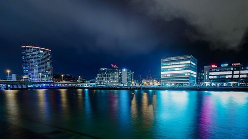 Illuminated buildings in city against sky at night