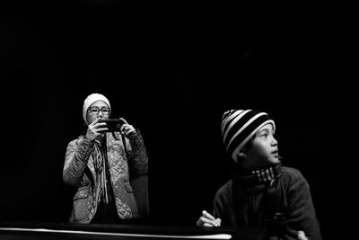 Mother photographing son in museum