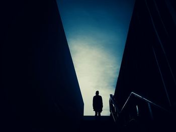 Low angle view of silhouette people standing against sky