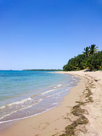 Scenic view of beach against clear blue sky