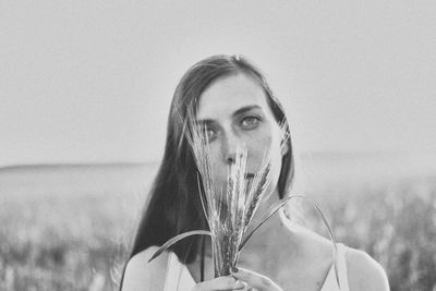 Portrait of young woman against sky