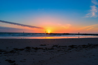 Scenic view of beach against sky during sunset