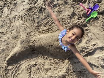 High angle view of happy girl on sand at beach