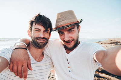 Portrait of smiling friends against sky