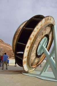 Rear view of people walking on metal structure