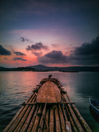 Pier over lake against sky during sunset