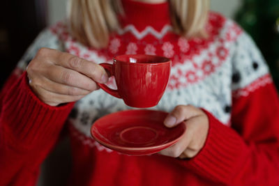 Midsection of woman holding coffee cup