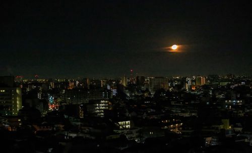 Illuminated buildings in city against sky at night