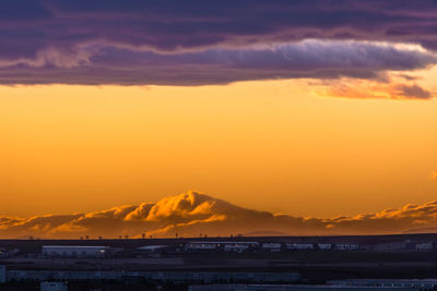 Scenic view of silhouette mountain against orange sky