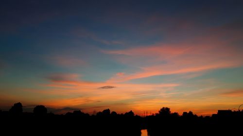 Silhouette trees against sky at sunset