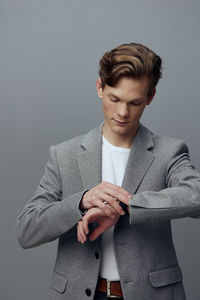 Portrait of young man standing against white background