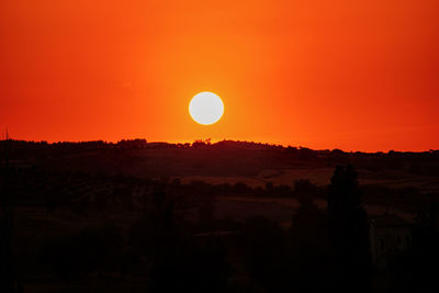 Scenic view of silhouette landscape against orange sky