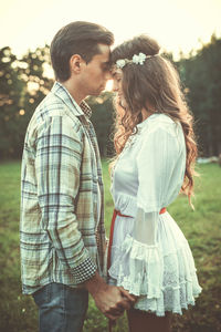 Rear view of couple standing on field